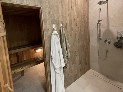 Custom Shower with Linear Tiled Drain, Woodgrain Tile and Floor Tile flowing into Sauna